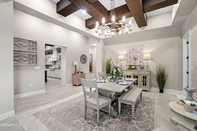 dining space with beamed ceiling, a high ceiling, coffered ceiling, and a notable chandelier