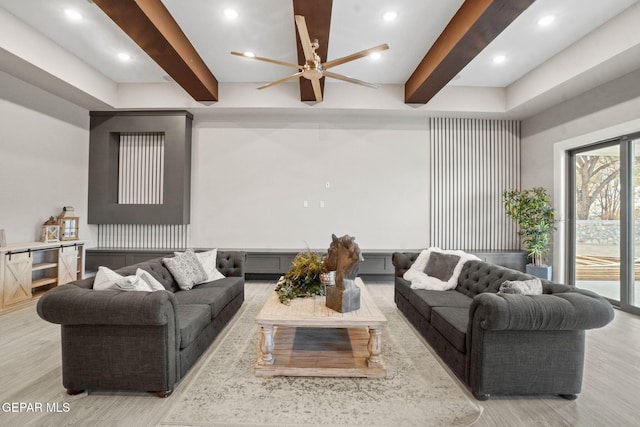 living room with beam ceiling, ceiling fan, and light wood-type flooring