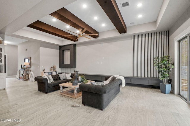 living room with ceiling fan, light hardwood / wood-style flooring, and beamed ceiling