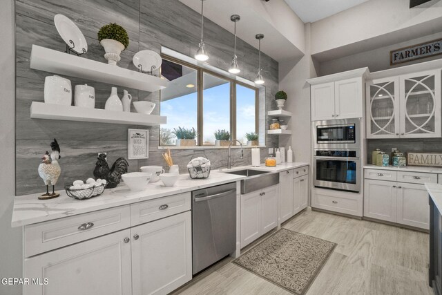 kitchen with white cabinets, stainless steel appliances, tasteful backsplash, and sink