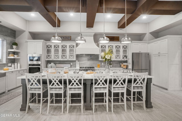 kitchen featuring a spacious island, premium range hood, and stainless steel appliances