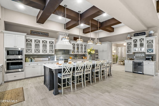 kitchen with white cabinetry, decorative backsplash, hanging light fixtures, and appliances with stainless steel finishes