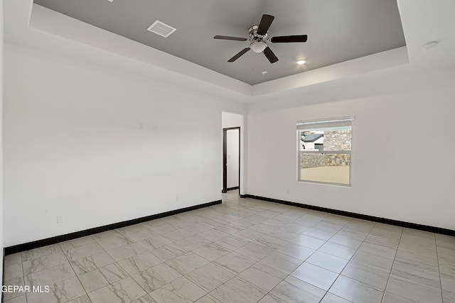 unfurnished room with a raised ceiling and ceiling fan