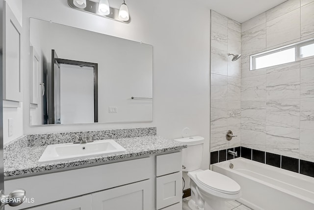 full bathroom with vanity, tiled shower / bath combo, and toilet