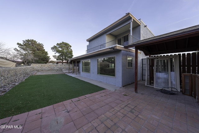 back of house with a patio, a balcony, and a lawn