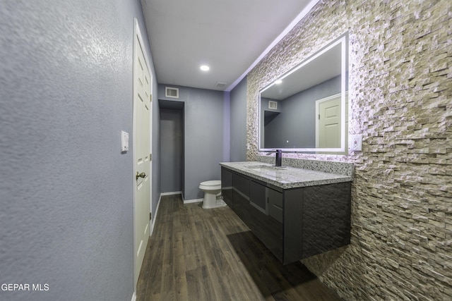 bathroom featuring hardwood / wood-style floors, vanity, toilet, and crown molding