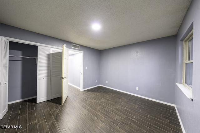 unfurnished bedroom with a textured ceiling and a closet