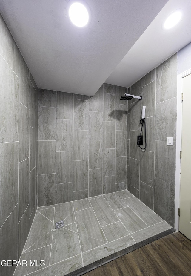 bathroom with hardwood / wood-style floors and tiled shower