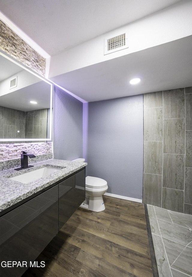 bathroom with hardwood / wood-style floors, vanity, and toilet