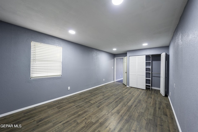 unfurnished bedroom with a closet and dark hardwood / wood-style floors