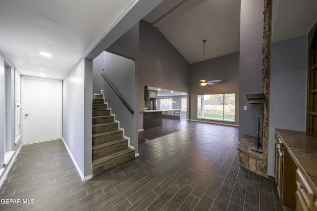 interior space with a towering ceiling and ceiling fan