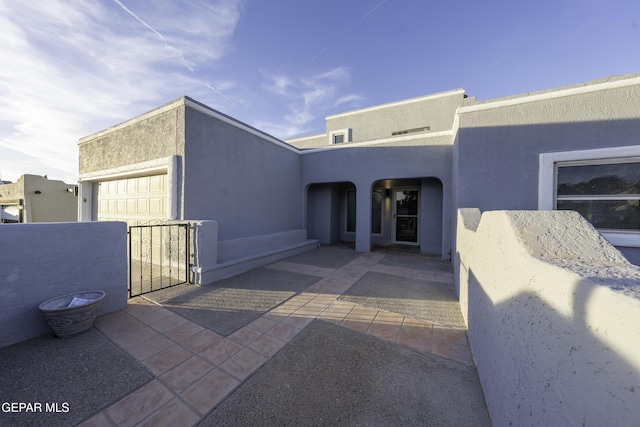 doorway to property featuring a patio and a garage