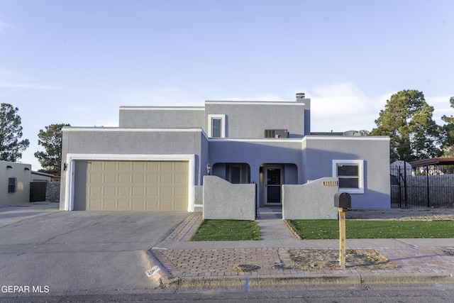 pueblo revival-style home featuring a garage