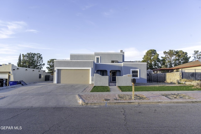 pueblo-style house featuring a garage