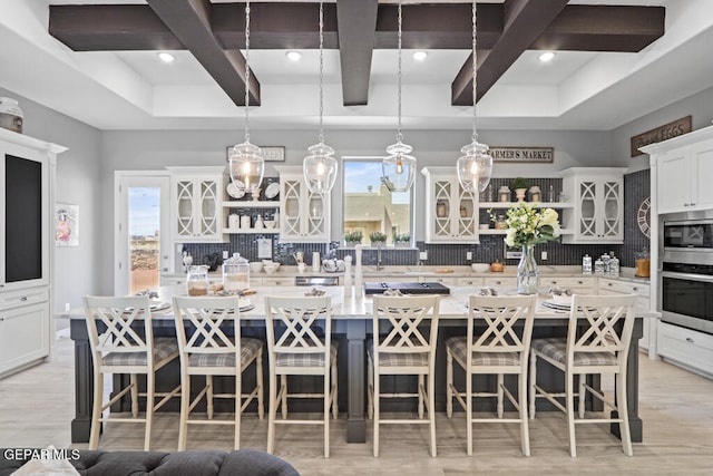 kitchen with pendant lighting, a breakfast bar, a spacious island, and appliances with stainless steel finishes