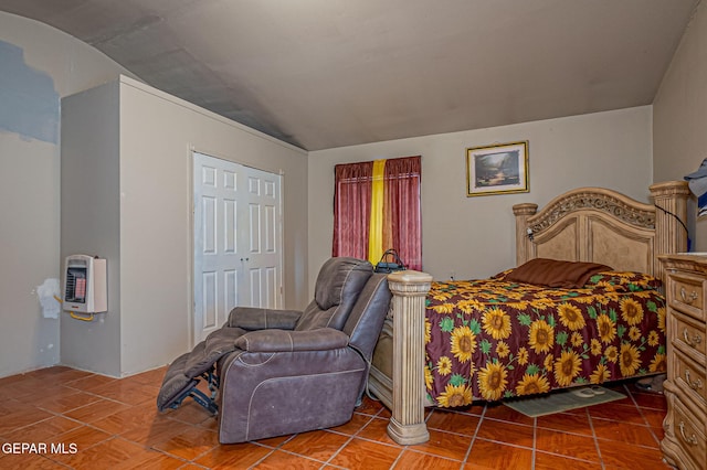 bedroom featuring a closet, vaulted ceiling, and heating unit