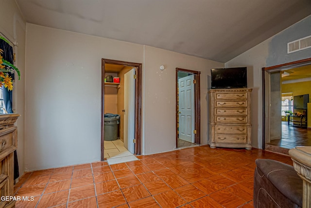 bedroom featuring ensuite bathroom and lofted ceiling