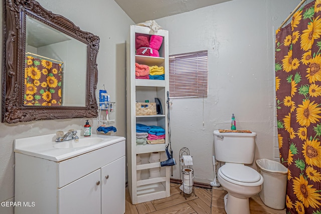 bathroom featuring vanity, toilet, and parquet flooring