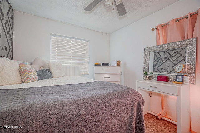 carpeted bedroom with ceiling fan and a textured ceiling