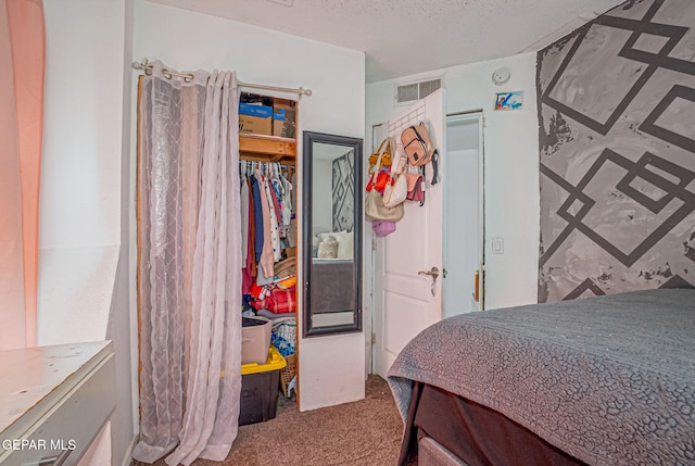 carpeted bedroom featuring a textured ceiling and a closet