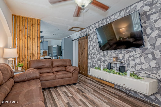 living room featuring a barn door and wood-type flooring