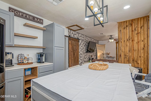 interior space with a barn door and ceiling fan