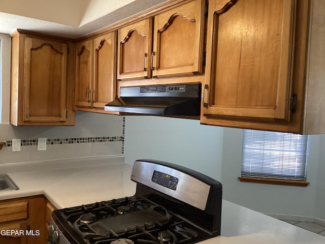 kitchen with gas stove and tasteful backsplash