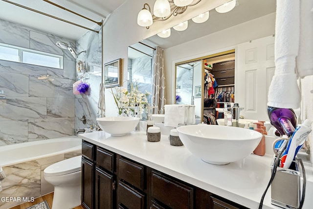 full bathroom featuring an inviting chandelier, hardwood / wood-style floors, toilet, vanity, and tiled shower / bath