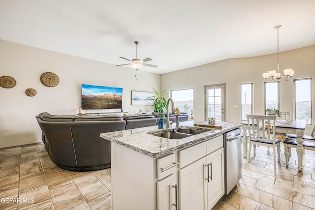 kitchen with dishwasher, a kitchen island with sink, white cabinets, sink, and light stone countertops