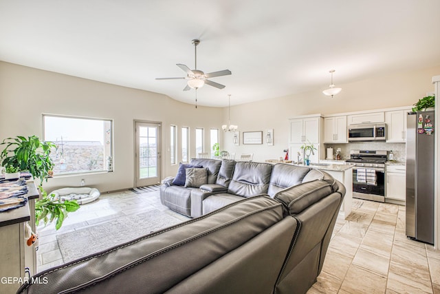 living room with ceiling fan with notable chandelier