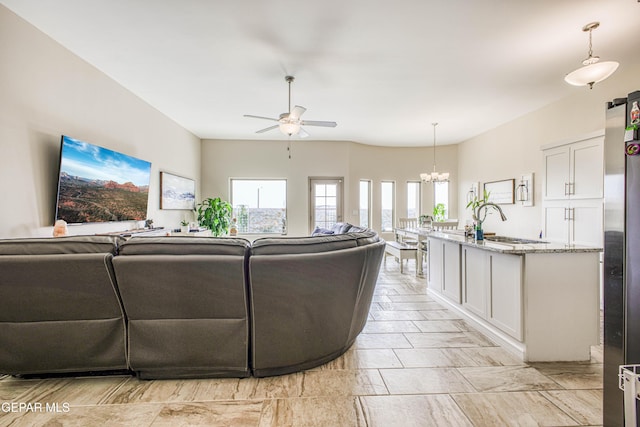 living room with ceiling fan with notable chandelier