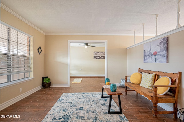 living room with a textured ceiling, ceiling fan, and crown molding