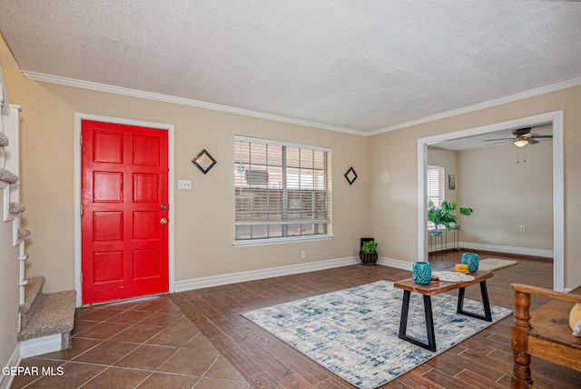 foyer with a textured ceiling, dark hardwood / wood-style floors, ceiling fan, and crown molding