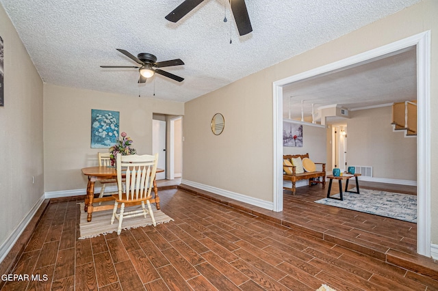 dining space featuring ceiling fan and a textured ceiling