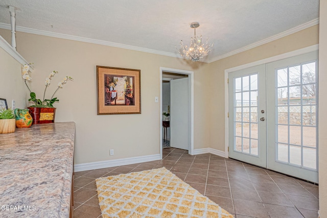 interior space featuring a notable chandelier, ornamental molding, a textured ceiling, and french doors