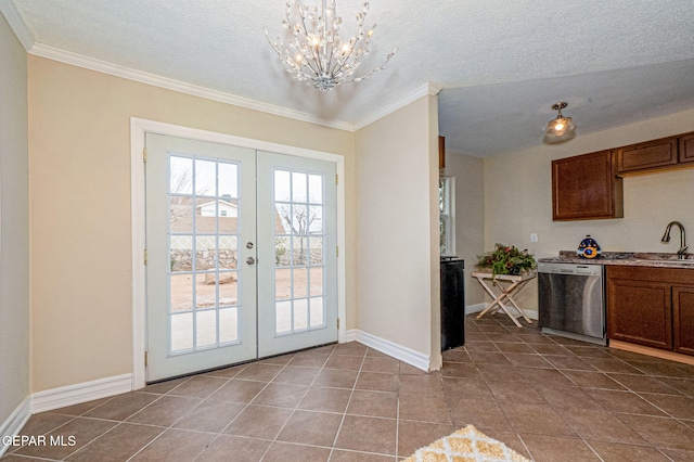 doorway with french doors, tile patterned floors, ornamental molding, and a notable chandelier