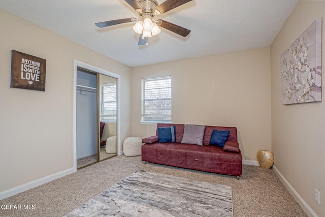 sitting room featuring ceiling fan, carpet floors, and a textured ceiling