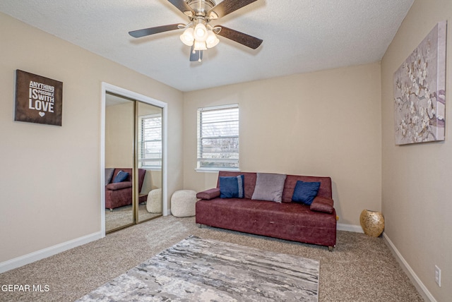 carpeted living room with a textured ceiling and ceiling fan