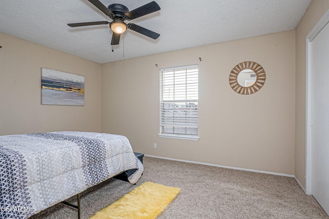 bedroom with carpet flooring, ceiling fan, and a textured ceiling