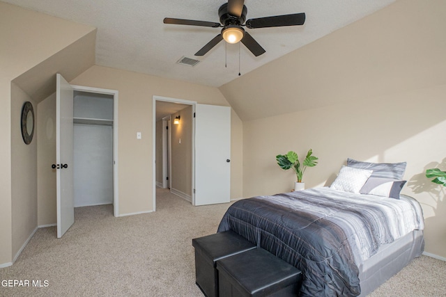 bedroom featuring a textured ceiling, light colored carpet, vaulted ceiling, and ceiling fan