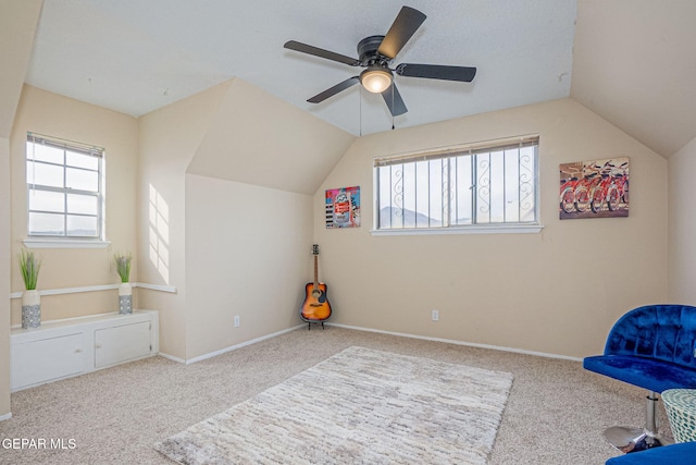 living area featuring ceiling fan, plenty of natural light, and light carpet