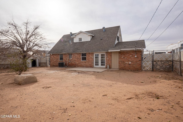 rear view of house with cooling unit, a patio area, a storage shed, and french doors