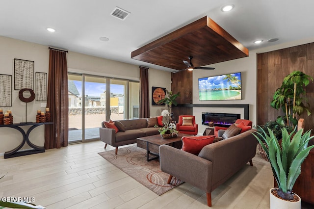 living room featuring light hardwood / wood-style flooring and ceiling fan