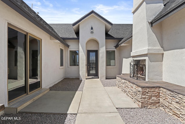 property entrance with exterior fireplace and a patio area