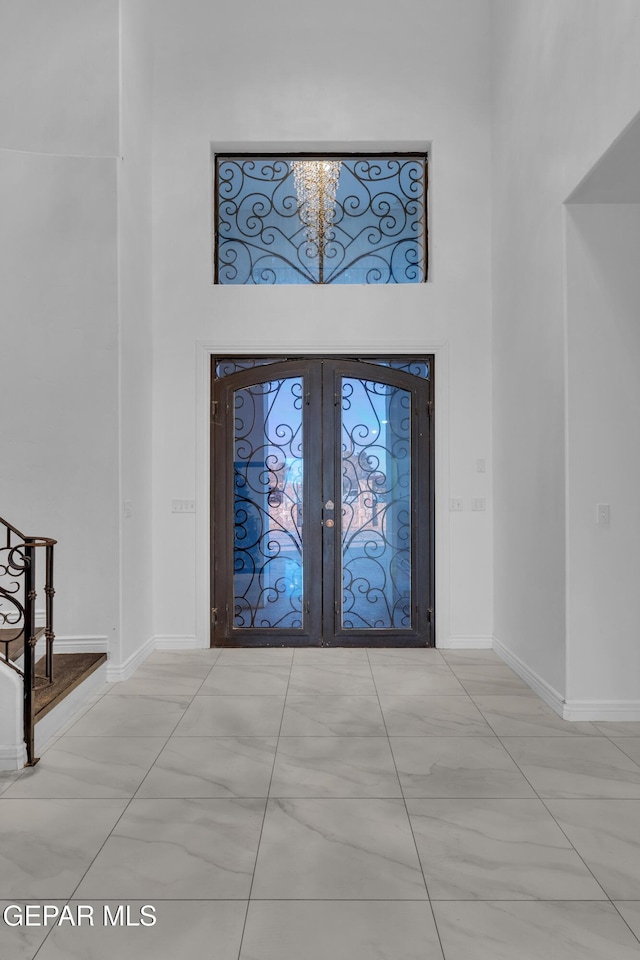 entrance foyer featuring a towering ceiling and french doors