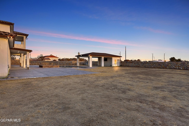 yard at dusk with a patio area