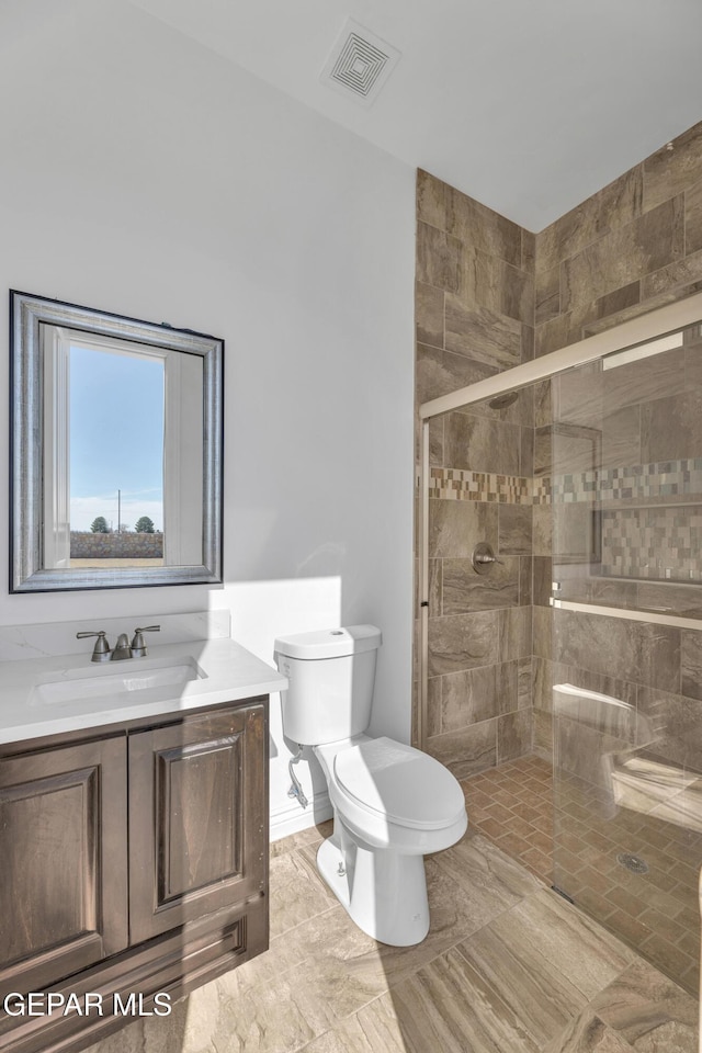 bathroom featuring toilet, vanity, tile patterned floors, and walk in shower