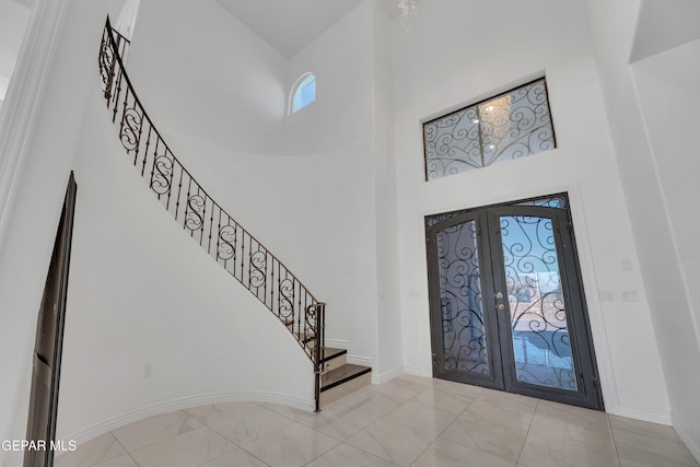 foyer entrance with french doors, a wealth of natural light, and a high ceiling