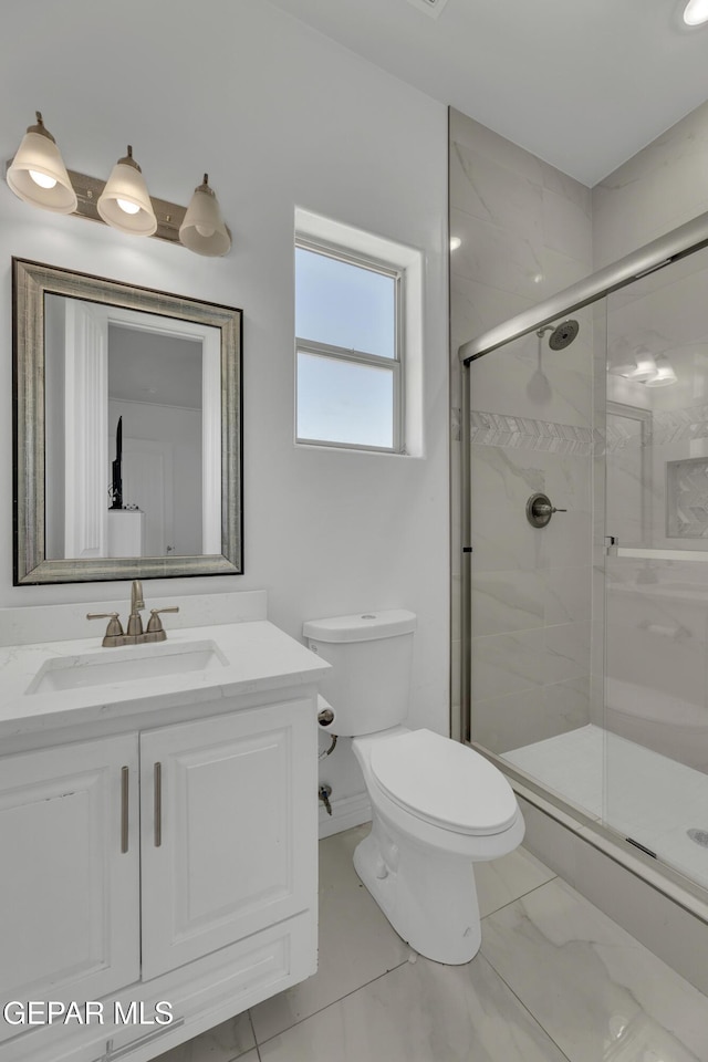 bathroom featuring vanity, toilet, and an enclosed shower