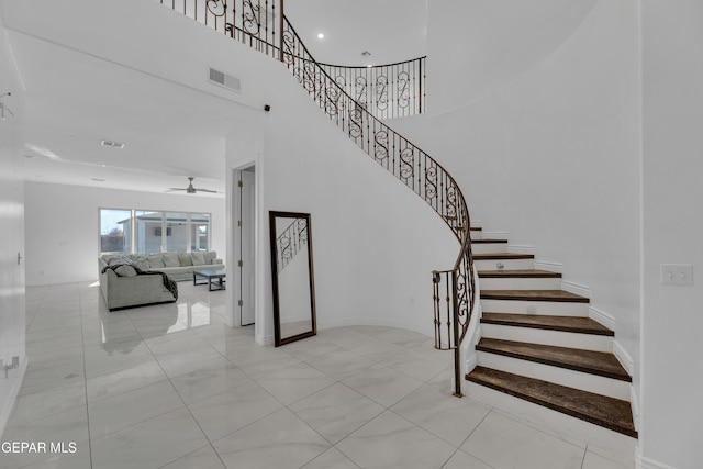 staircase featuring ceiling fan